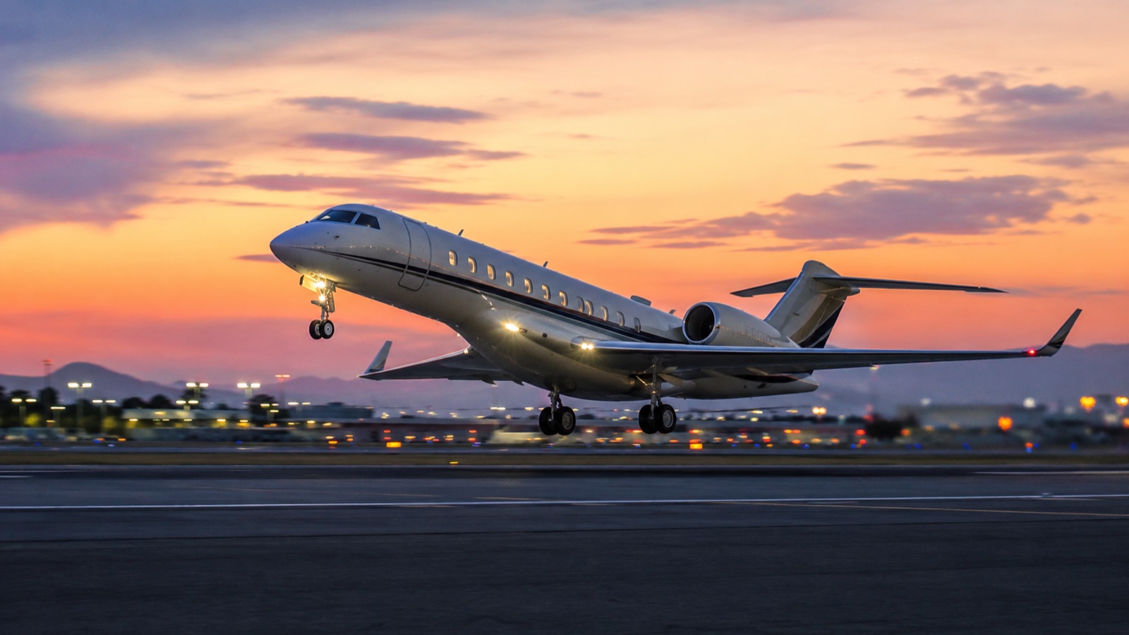 Business jet lifting off at dusk